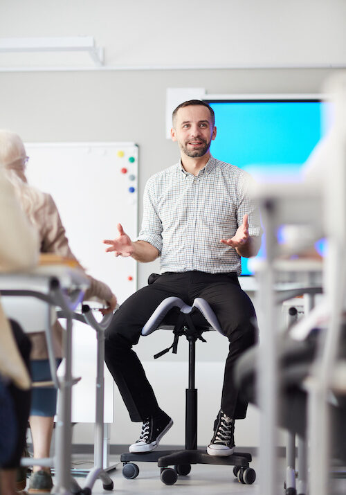 Male Teacher in front of classroom talking